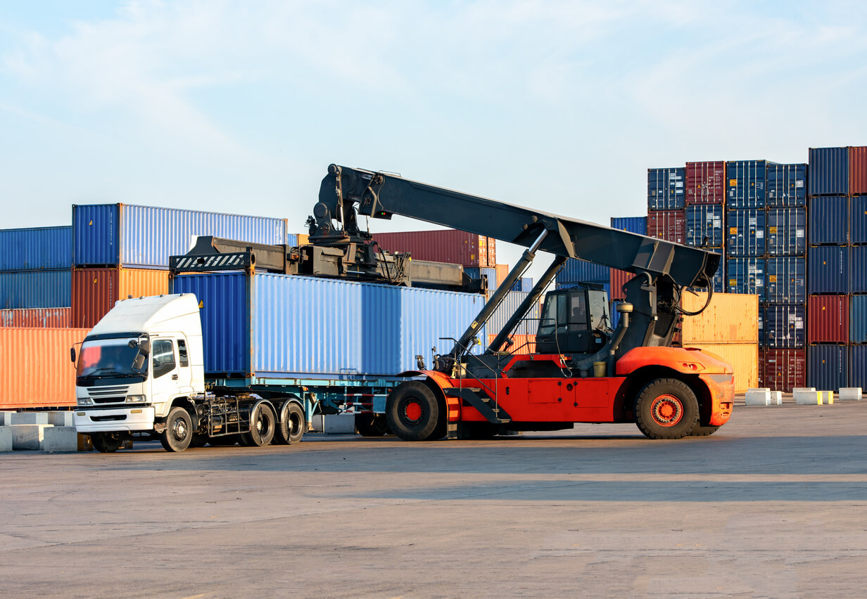 Reachstacker handling loading Containers At Industrial Port And Container Yard To Truck