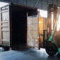 forklift loading palletised goods into a shipping container.